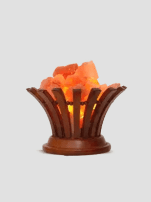 "Himalayan pink salt lamp in flared wooden basket design - Suhail Salt manufacturer - glowing natural salt crystals with warm orange light"