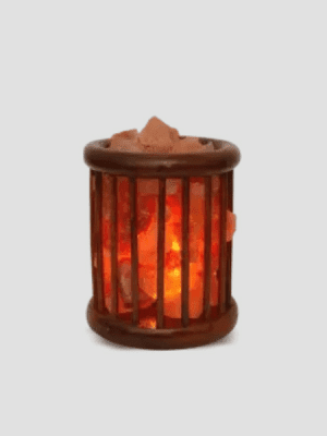 "Himalayan pink salt lamp in wooden cage basket design - Suhail Salt manufacturer - glowing natural salt chunks with warm amber light"