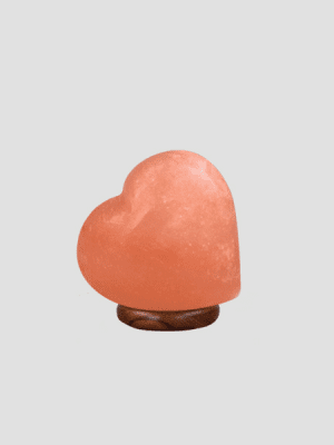 Hand-carved heart-shaped Himalayan pink salt lamp on a premium wooden base, manufactured by Suhail Salt, a leading exporter of authentic salt products.